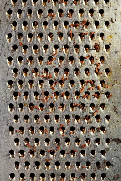 Pieces of chocolate on aluminum grater — Stock Photo, Image