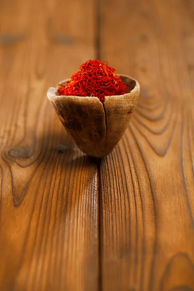 Saffron spice in antique wooden bowl — Stock Photo, Image