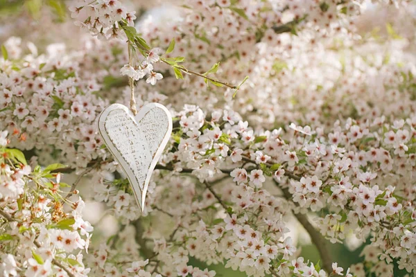 Corazón de madera en flores —  Fotos de Stock