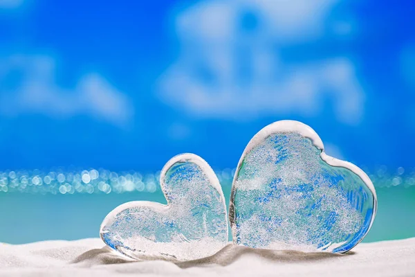 Deux cœurs en verre clair sur la plage — Photo