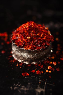 harissa baharat karışımı koyu arka planı, geleneksel Fas kırmızı sıcak biber karışımı üzerinde küçük metal kapta yığını