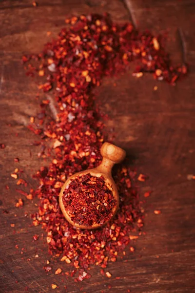 pile of harissa spice mix in wooden scoop, traditional Moroccan red hot chilli mix