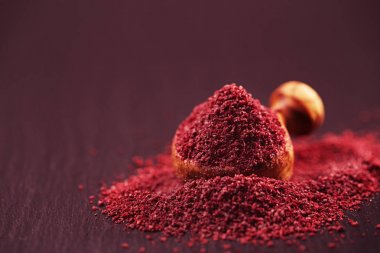 close-up view of Ground Red Sumac Berries spice on black plate clipart