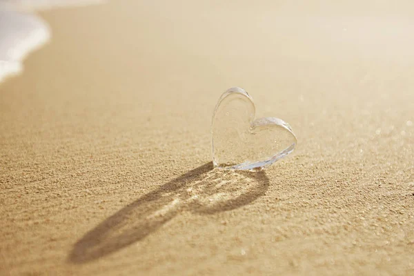 Прозрачное Стеклянное Сердце Песчаном Пляже Волнами — стоковое фото