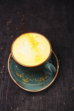 Zerdeçal latte veya ahşap zemin üzerine altın süt