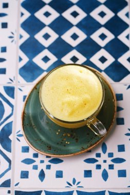 Zerdeçal latte veya renkli arka plan üzerinde parlak yıldız ile altın süt