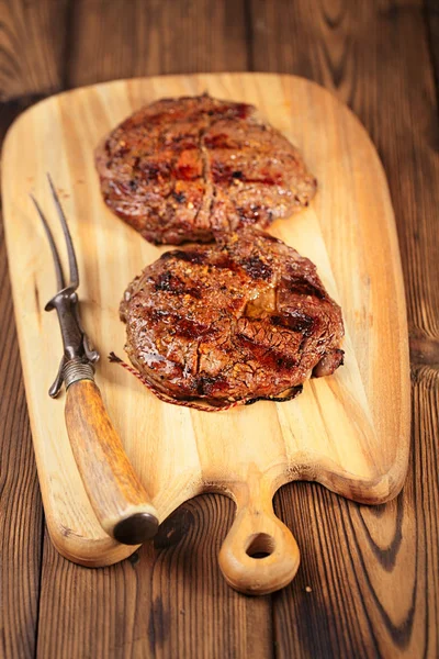 Carne de alimentos - bife de carne em tábua de madeira — Fotografia de Stock