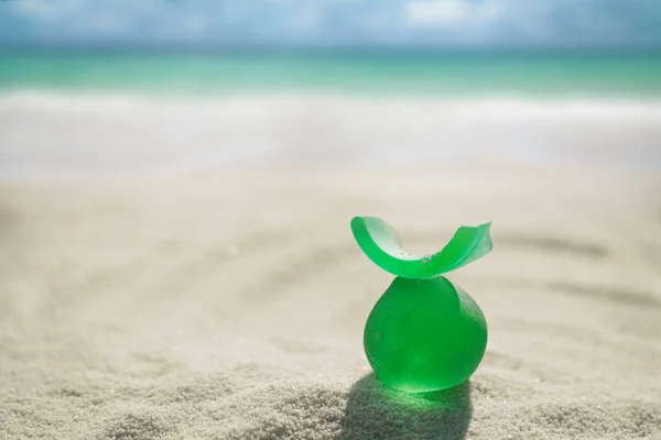 Sea glass on white sand beach — Stock Photo, Image