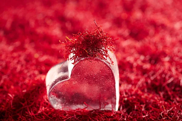 Wątki szafranowe tło ze szklanym sercem — Zdjęcie stockowe