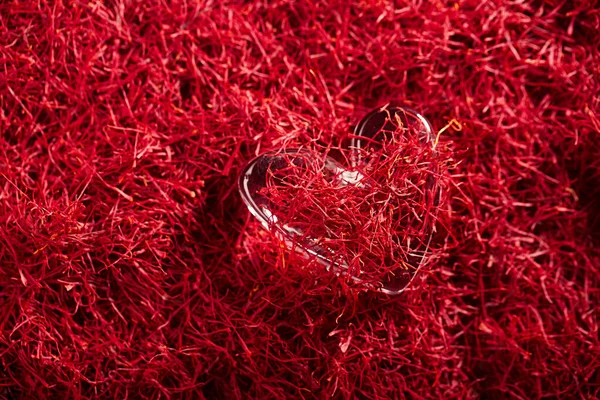 Saffron threads background with glass heart — ストック写真