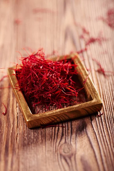 Saffron threads  pile with vintage wood backdrop — Stock Photo, Image