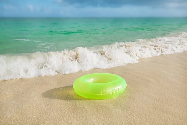 Κυμαινόμενο δαχτυλίδι σε αμμώδη παραλία με κύματα — Φωτογραφία Αρχείου