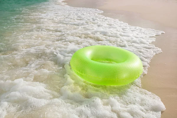 Плавающее кольцо на песчаном пляже с волнами — стоковое фото