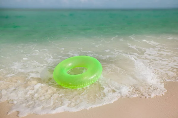 Floating ring on sandy beach with waves — 스톡 사진
