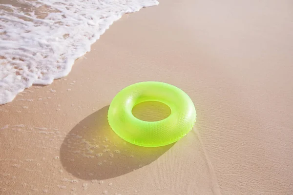 Floating ring on sandy beach with waves ストック画像