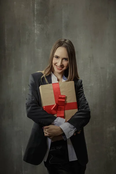 Chica sexy en chaqueta clásica y camisa con un regalo en las manos s —  Fotos de Stock