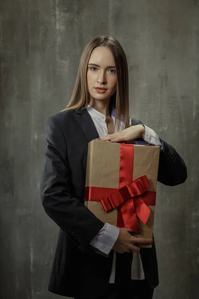 Chica sexy en chaqueta clásica y camisa con un regalo en las manos s —  Fotos de Stock