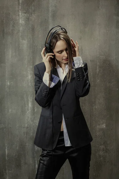 Sexy girl in classic jacket and shirt with headphones on his hea — Stock Photo, Image