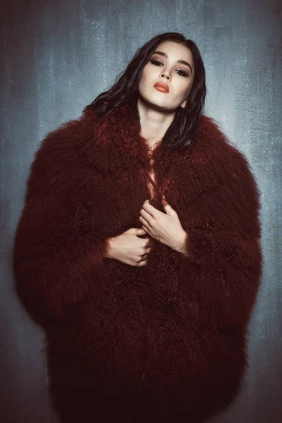 Όμορφη κοπέλα με το μεγάλο κόκκινο και χνουδωτό παλτό μόνιμη — Φωτογραφία Αρχείου