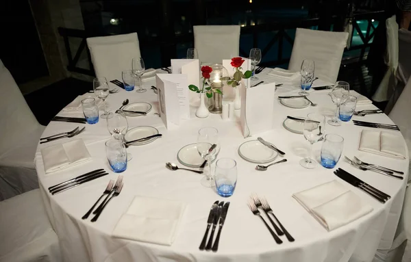 Roundtable serviert Restaurant am Abend, mit Blumen und C — Stockfoto