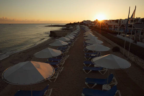 Playa del hotel en la playa con tumbonas y sombrillas al amanecer —  Fotos de Stock