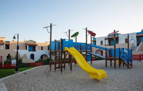 Parque infantil con tobogán y columpio al amanecer —  Fotos de Stock