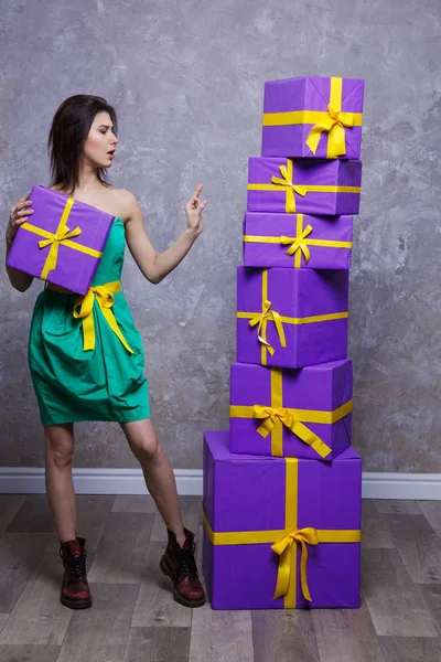 Una joven con un vestido y botas con un regalo en las manos, Stan —  Fotos de Stock