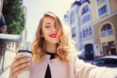Bir bardak kahve onun elinde genç kız yapar selfie 