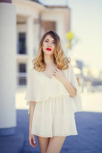 Portrait of a young girl in a light dress on a background of a s — Stock Photo, Image