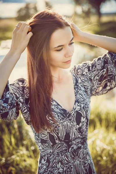 Retrato de uma jovem menina bonita em um vestido longo de pé em t — Fotografia de Stock