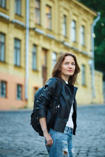 Bir kız kot pantolon ve bir deri ceket bir şehir sokak standları