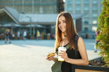 Genç bir kız yemek lokanta kasaba meydanında vardır.
