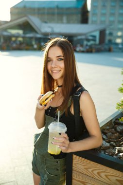 Genç bir kız yemek lokanta kasaba meydanında vardır.