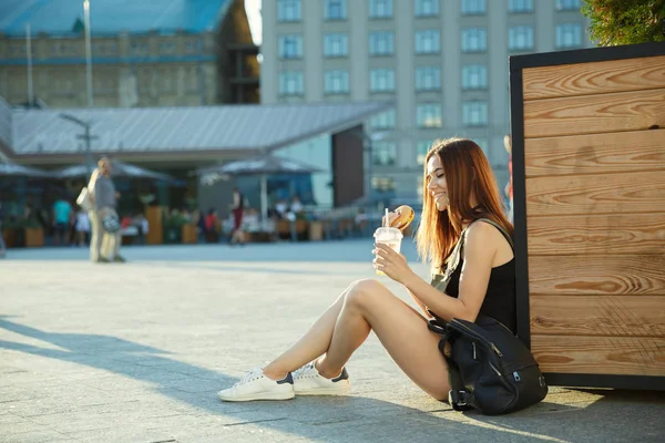 Una giovane ragazza cena fast food nella piazza della città — Foto Stock