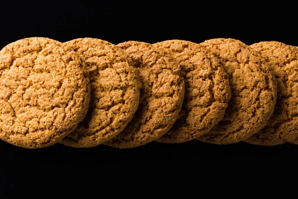 Μοτίβο της πλιγούρι βρώμης cookies που απομονώνονται σε ένα μαύρο φόντο — Φωτογραφία Αρχείου