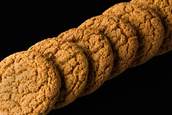 Μοτίβο της πλιγούρι βρώμης cookies που απομονώνονται σε ένα μαύρο φόντο — Φωτογραφία Αρχείου