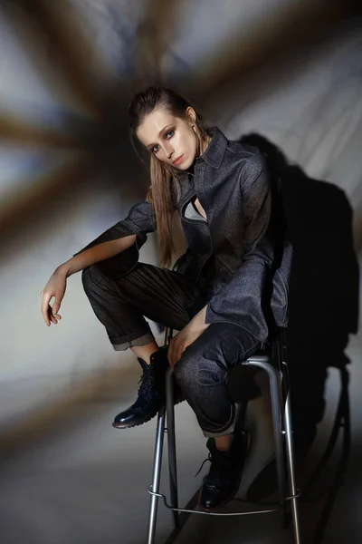 Artistic portrait of a woman in a denim suit on a gray backgroun — Stock Photo, Image