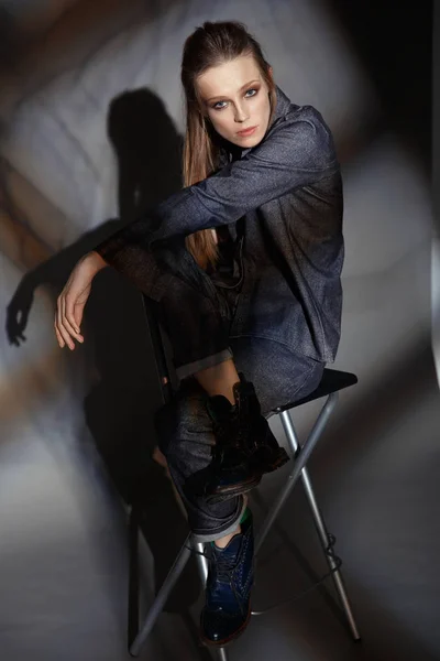 Künstlerisches Porträt einer Frau im Jeansanzug auf grauem Hintergrund — Stockfoto