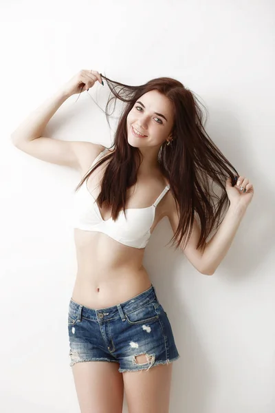 Emotional portrait of a young, sexy girl in shorts and a bra on — Stock Photo, Image