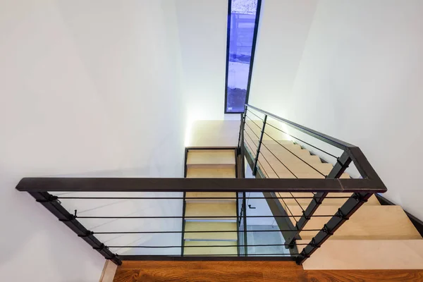 Лестница в частном доме с деревянными ступенями и металлическими перилами — стоковое фото