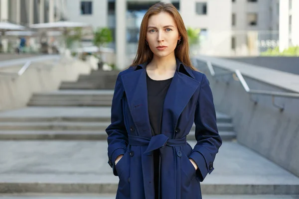 Portrait of a woman in a coat on the background of the city and — Stock Photo, Image