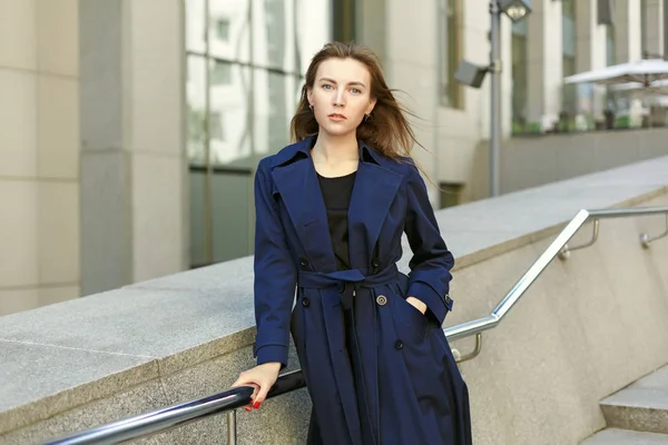 Portrét ženy v kabátě na pozadí města a — Stock fotografie
