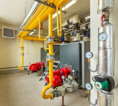 Kazan ve boru hatları olan endüstriyel bir gaz kazan dairesi..