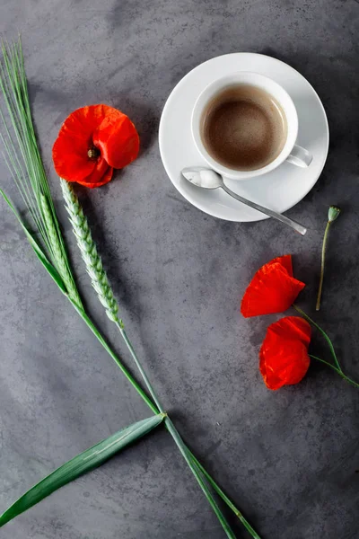Tazza di caffè nero con fiori selvatici - papaveri, su grigio gru — Foto Stock