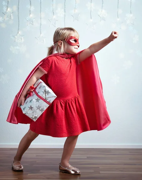 Маленькая девочка в костюме супергероя и маске, изображающей супергероя — стоковое фото