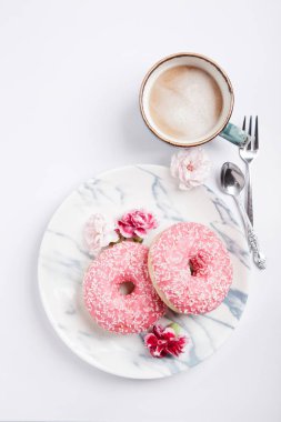 Bir fincan kapuçino, beyaz üzerine iki taze çörek