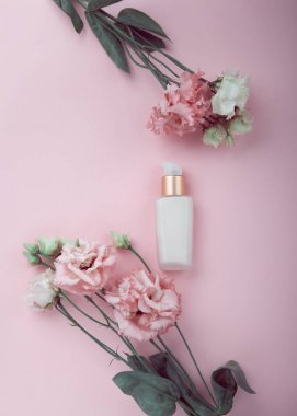 Yüz kremi taze pembe ve beyaz çiçekler ile flatlay pembe üzerinde