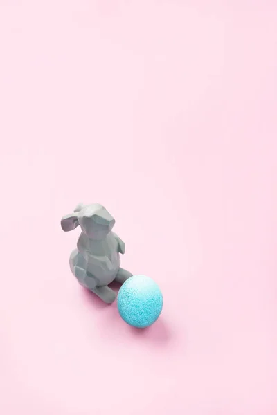 Pasen konijn beeldje met een blauw geschilderde easter egg — Stockfoto
