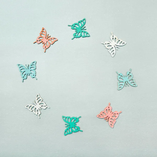 Schmetterlingsausschnitte im Kreis angeordnet, Flatlay auf Grau, mit Copyspace — Stockfoto