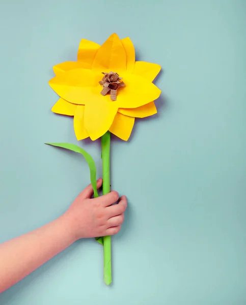 Kind handen met een handgemaakte zonnebloem — Stockfoto